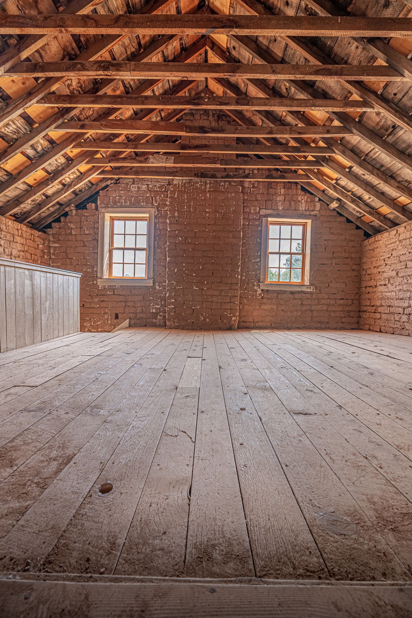Combles à charpente apparente et murs en brique, configuration typique du bâti ancien où s'installent les rats noirs
